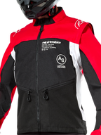 Alpinestars Pro-Dura Jacke, Offroad-Motorradjacke, Schwarz, Hellrot und Weiß, getragen mit einem schwarzen Helm, mit Reißverschlusstaschen und auffälligem Branding auf der Brust, strapazierfähige Textilkonstruktion für Enduro- und Trail-Fahrten