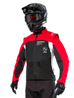 Alpinestars Pro-Dura Jacke, Offroad-Enduro-Motorradjacke, Schwarz mit leuchtendem Rot und weißem Colorblocking, getragen von einem Fahrer mit schwarzem Helm und Brille, mit vorderen Reißverschlusstaschen und Alpinestars-Branding, strapazierfähige Textilkonstruktion für Trail-Fahrten
