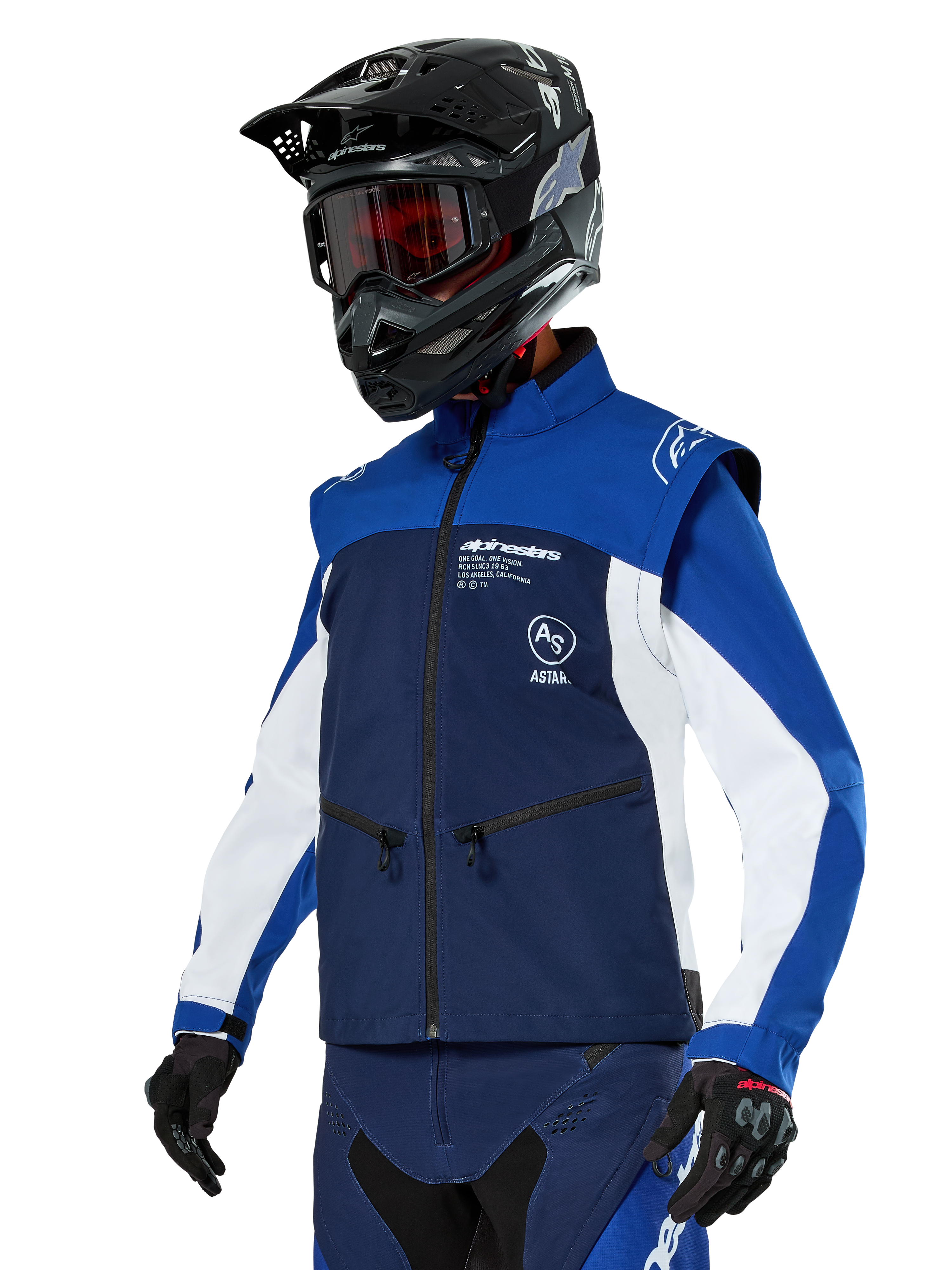 Alpinestars Lite-Dura Softshell-Jacke, Navy, Hellblau und Weiß, Offroad-Enduro-Jacke, getragen mit schwarzem Helm und rot getönter Brille, sportliches Color-Block-Design mit mehreren Reißverschlüssen und Markenlogos, strapazierfähiges Textil für Motocross und Trail-Fahrten