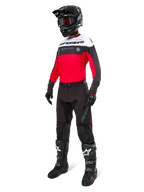 Alpinestars Pro-Dura Hose in Black Magnet White, getragen von einem Fahrer mit passendem rot-schwarz-weißem Trikot, schwarzem Helm und schwarzen Offroad-Stiefeln, komplettes professionelles Enduro-Rennsport-Ausrüstungsset für Offroad-Performance.