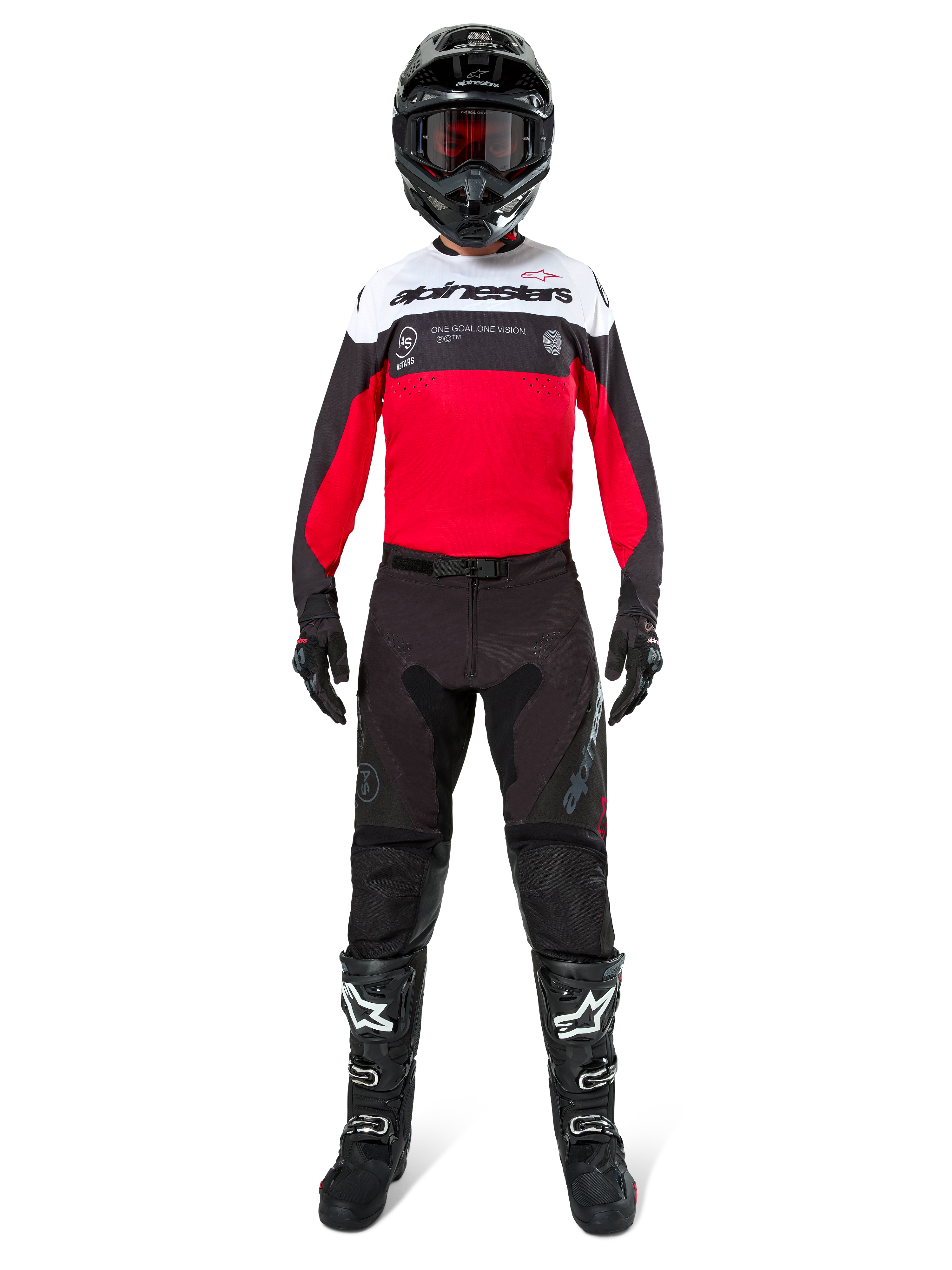 Motocross-Fahrer in Alpinestars Pro-Dura Hose in Schwarz und Magnet, kombiniert mit einem rot-weiß-schwarzen Trikot, schwarzem Helm und schwarzen Stiefeln, komplette Offroad-Rennausrüstung, strapazierfähiges und leichtes Design für Enduro-Fahrten