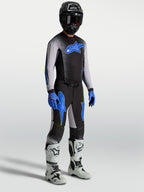 Alpinestars Supertech Hiten AFD Hose, Motocross-Set für Herren in Schwarz und Blau am Model mit Trikot und weißen Stiefeln.