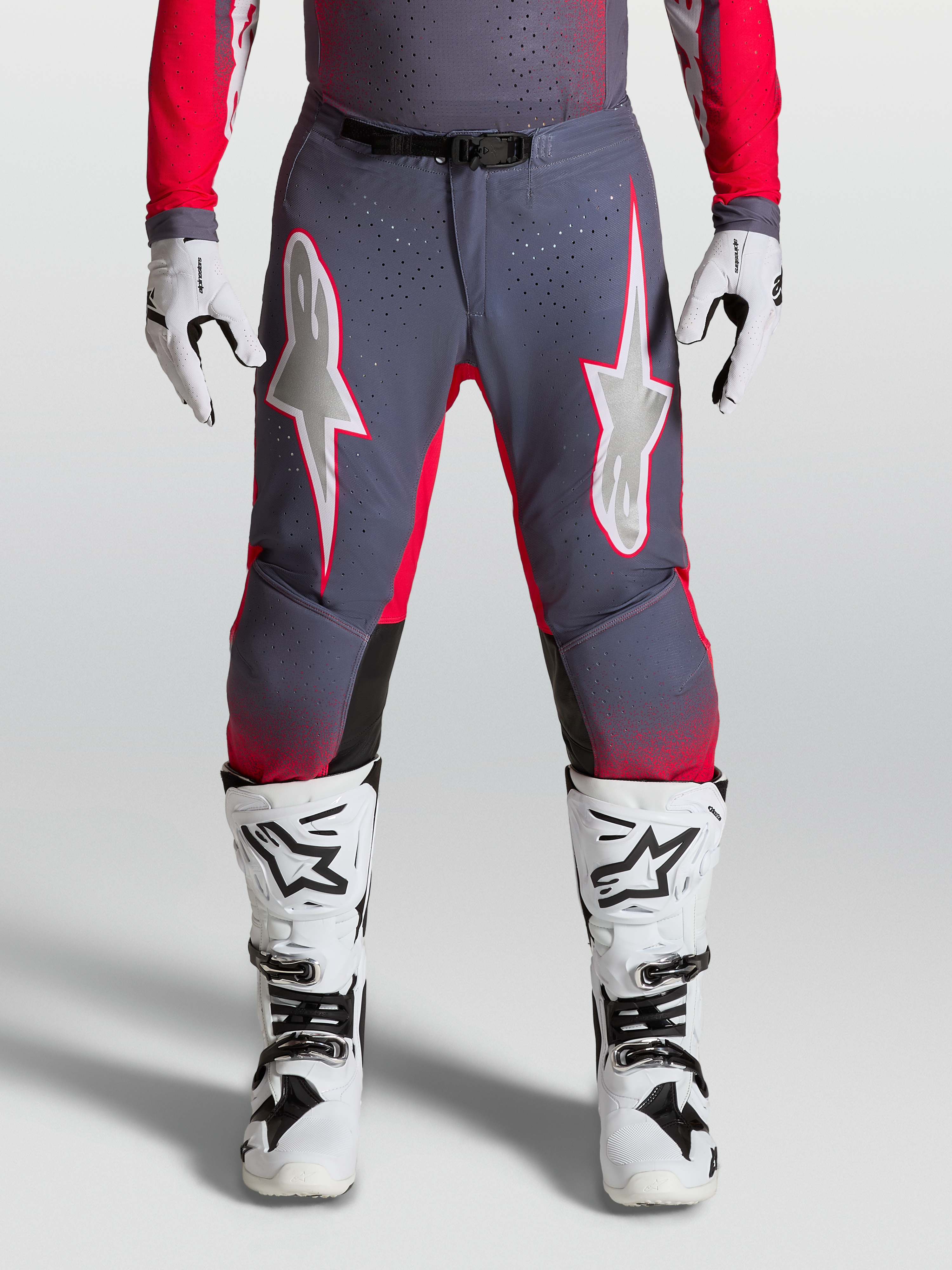 Alpinestars Supertech Hiten AFD Hose, Motocross-Hose in Grau und Rot-Fluo mit lilafarbenen Sterngrafiken, perforierte Stretch-Paneele, athletische Passform.