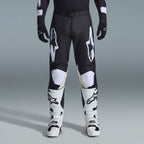 Alpinestars 2026 Racer Air Riway Gear Set, Black and White motocross pants with tan inner knee panels, paired with white racing boots and black gloves, lightweight ventilated off-road racing gear