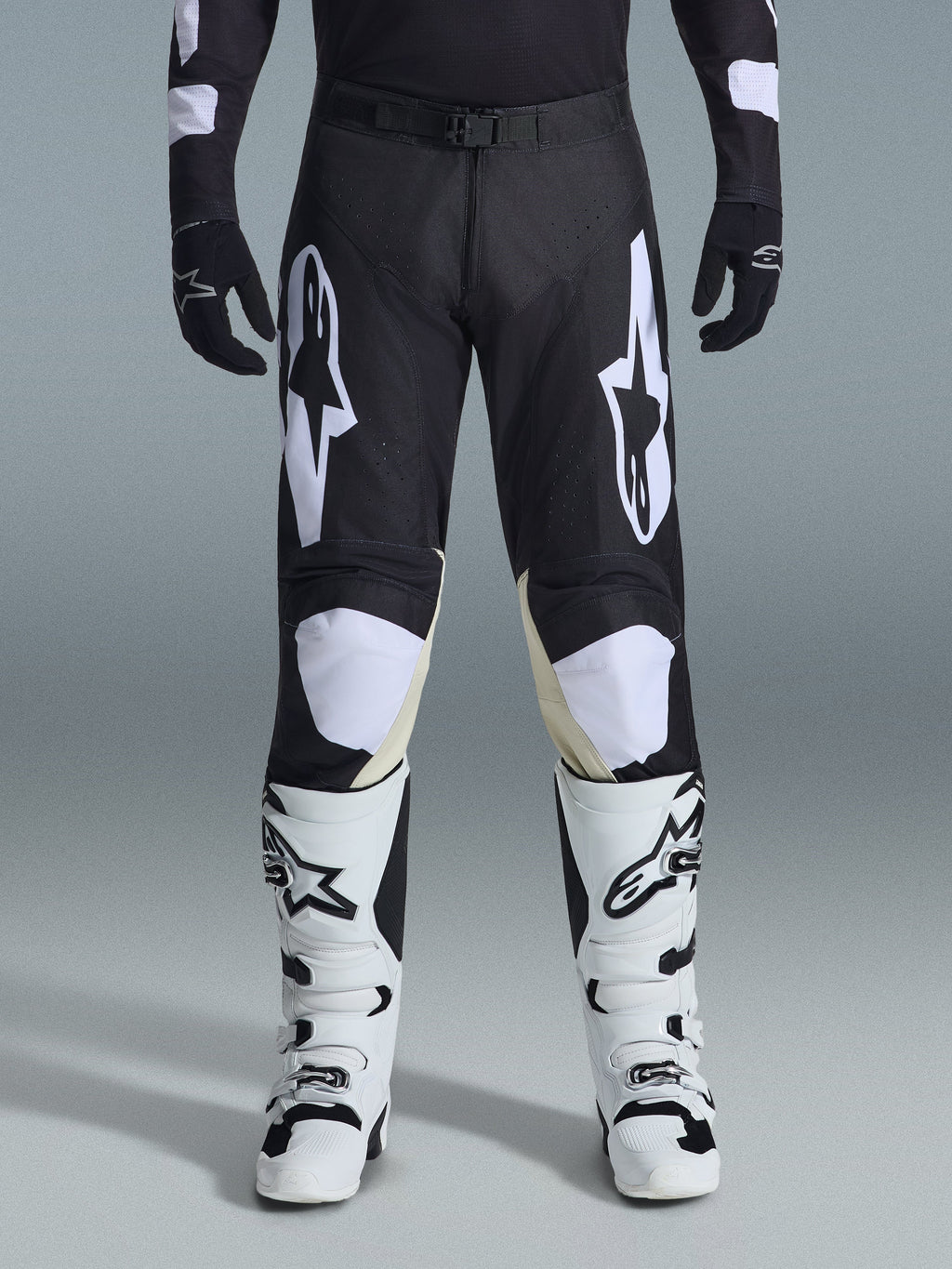 Alpinestars 2026 Racer Air Riway Hose, Motocross-Hose, Schwarz und Weiß, mit markanten weißen Alpinestars-Logos an den Oberschenkeln und Knie-Einsätzen, kombiniert mit weiß-schwarzen Motocross-Stiefeln und schwarzen Handschuhen, athletische Rennpassform für den Offroad-Sport