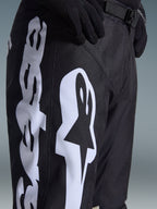 Alpinestars 2026 Racer Air Riway Hose, Motocross-Hose, Schwarz und Weiß, Detailansicht mit großem weißem Alpinestars-Branding, lasergeschnittenen Perforationen für Luftzirkulation und verstellbarer Taillenschnalle, strapazierfähiges Material für Offroad-Einsätze.