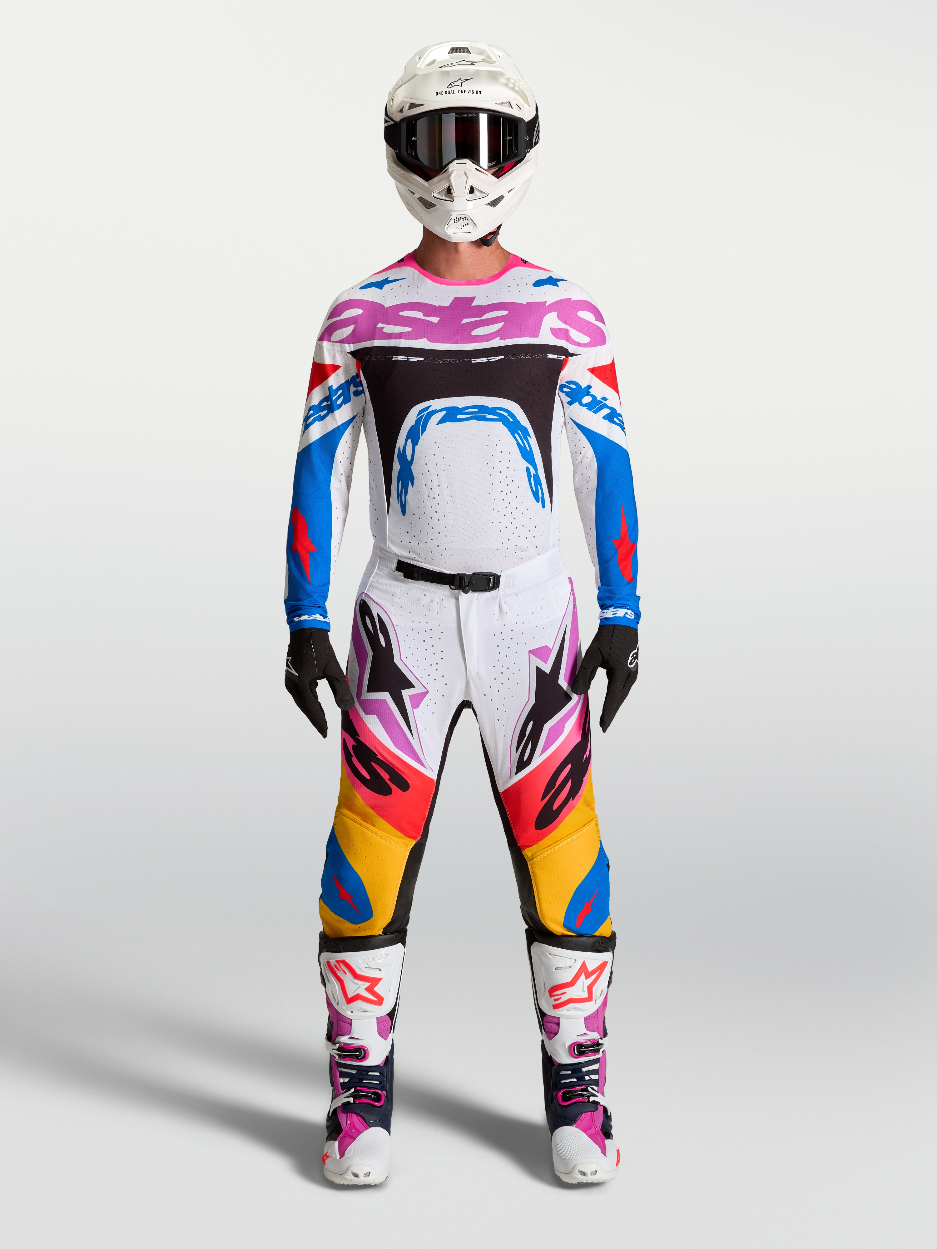 Alpinestars Supertech Dyna Hosen und Rennausrüstung, Herren-Motocross-Outfit in Weiß und Blau mit pinken Akzenten.