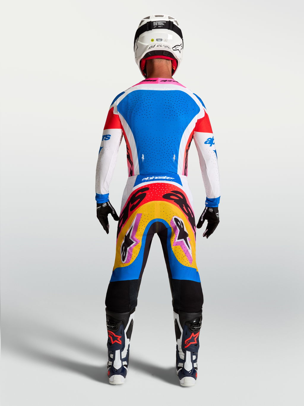 Alpinestars Supertech Dyna Motocross-Set, Herren-Trikot und Hose in Blau und Weiß mit bunten Grafiken, Rückansicht am Model.