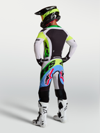 Alpinestars Supertech Dyna Motocross-Ausrüstung für Herren, Supertech Dyna Hose und Trikot in Grün Fluo, Schwarz und Helllila, Rückansicht eines Fahrers.