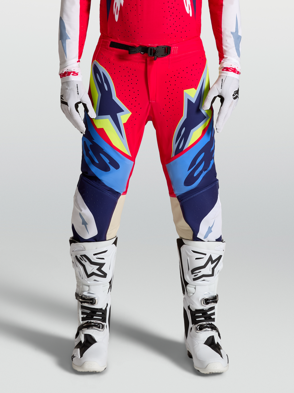 Alpinestars Supertech Dyna Hose, Motocross-Hose f61r Herren, Rot und Blau mit gelben Akzenten, getragen mit wei62en Stiefeln und Handschuhen, SX1 Magnetverschluss und Ziegenleder-Kniepanels