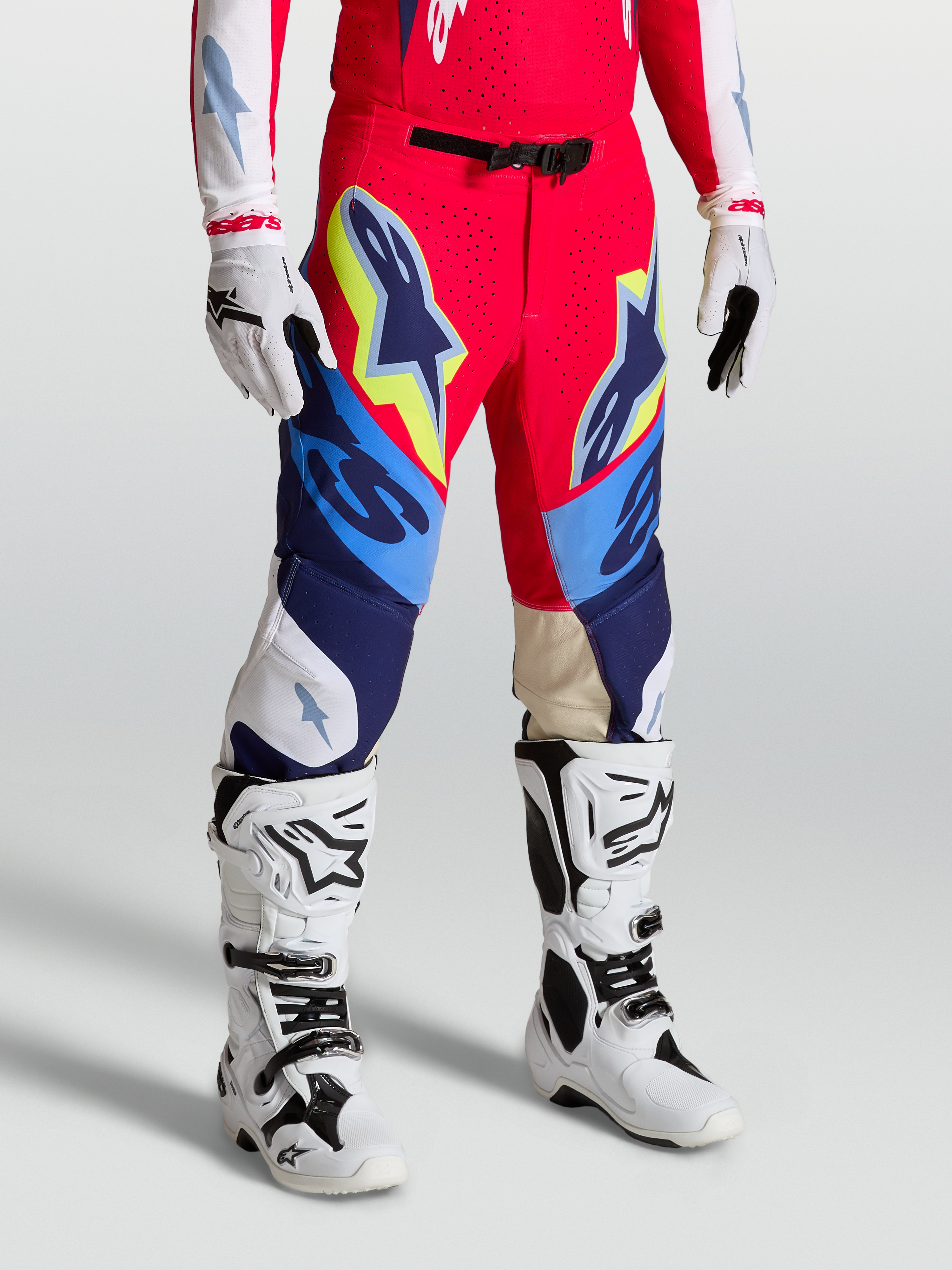 Alpinestars Supertech Dyna Hose, Motocross-Hose in Rot, Weiß und Navy-Blau, athletische Rennpassform mit Stretch-Ripstop-Gewebe, getragen mit Tech 10 Stiefeln und Handschuhen, professionelle Offroad-Ausrüstung.