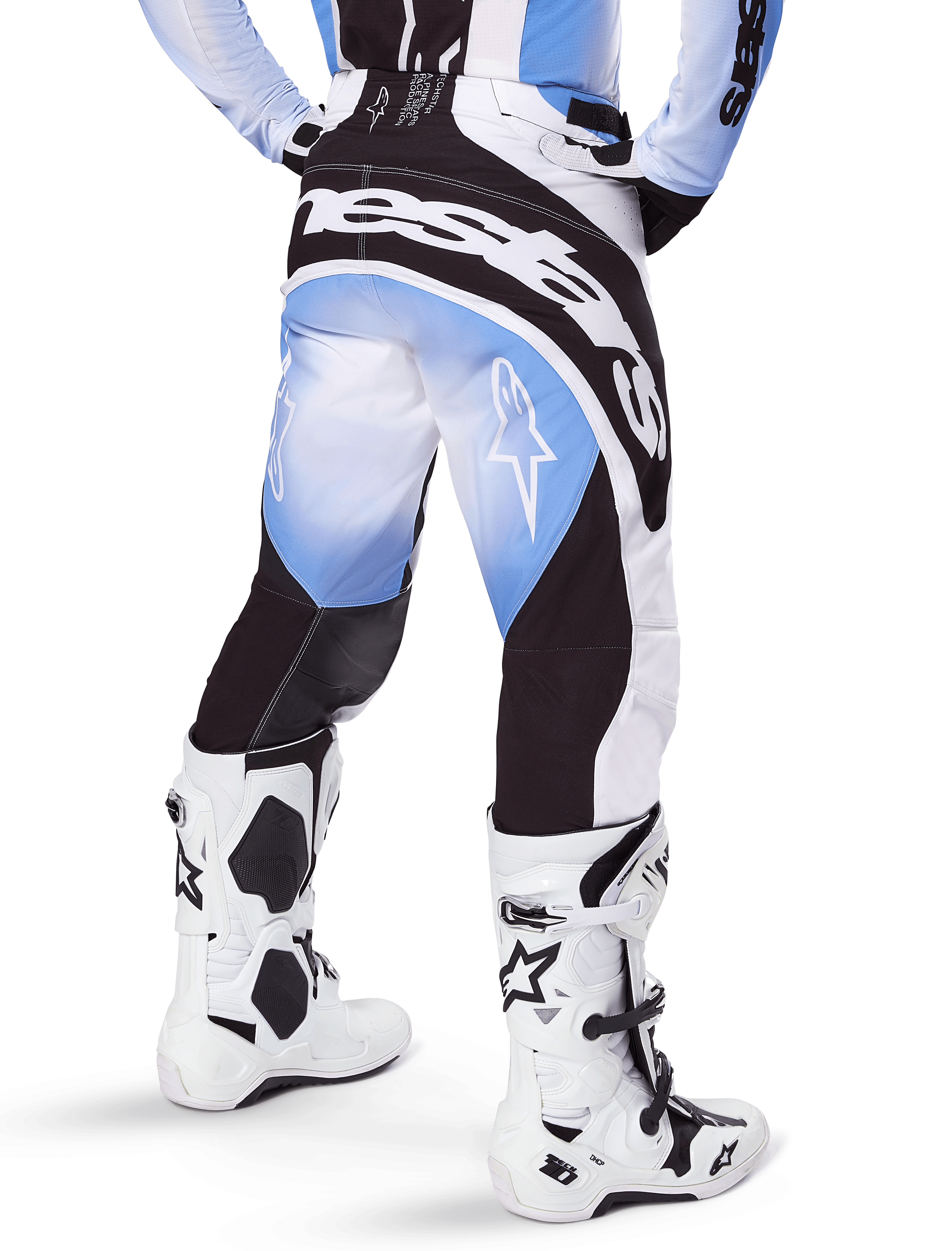 Alpinestars 2025 Techstar Melt Hose, Motocross-Hose, Schwarz, Blau und Weiß, Rückansicht mit markantem Alpinestars-Schriftzug am Gesäß und Stern-Logos auf den Beinen, kombiniert mit weiß-schwarzen Tech 10 Stiefeln, professionelle Offroad-Rennausrüstung
