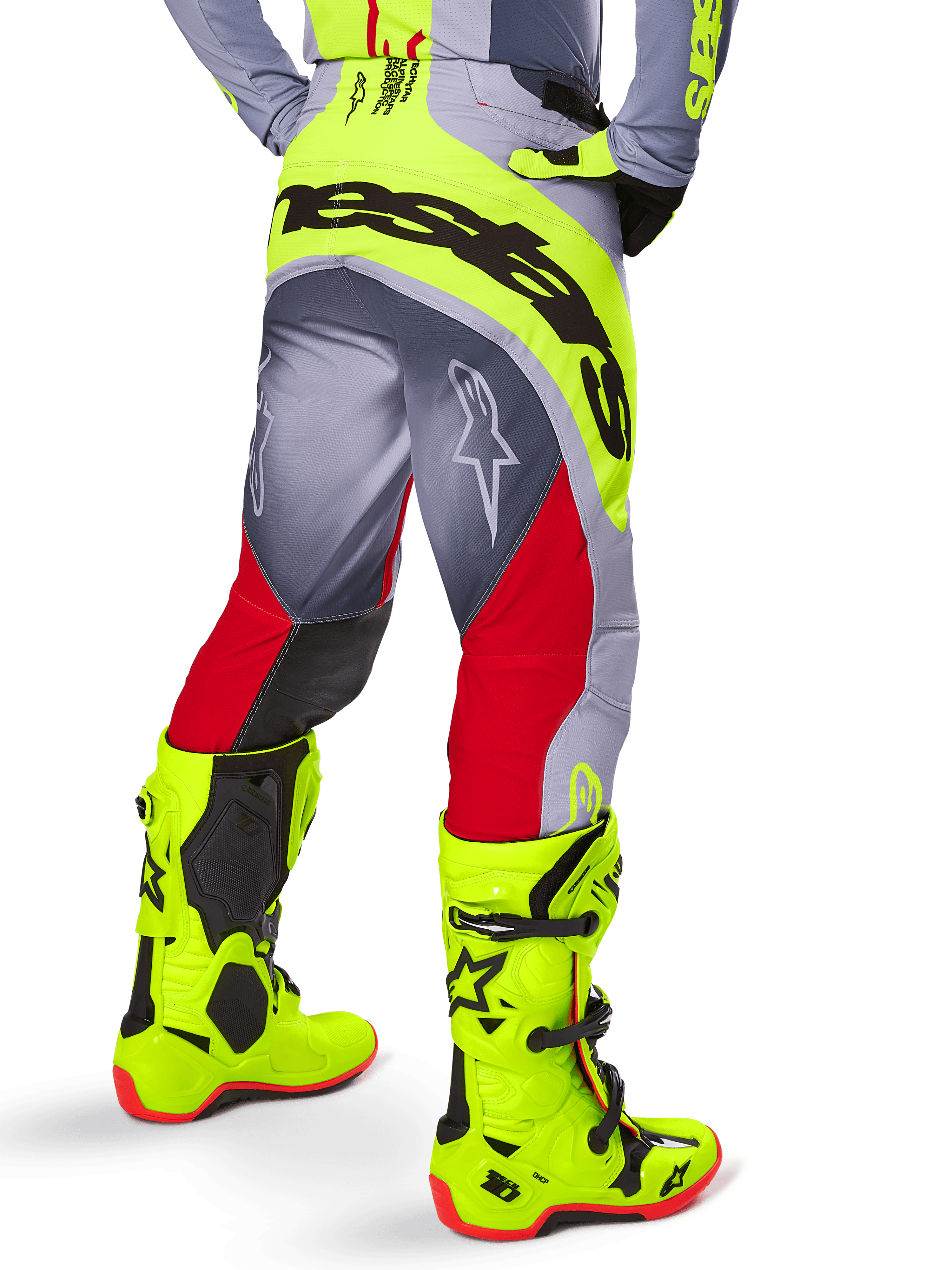 Alpinestars 2025 Techstar Melt Pants, Motocross Pants, Bright Red and Gray with neon yellow accents, rear view highlighting large black branding on the seat, worn with matching bright yellow boots and a gray jersey, athletic race fit for off-road competition.