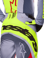 Alpinestars 2025 Techstar Melt Hose, Nahaufnahme des Gesäß- und Taillenbereichs, grau-neongelbes Design mit großem schwarzem Branding, Stern-Logos und Race-Spec-Text, Hochleistungs-Motocross-Ausrüstung