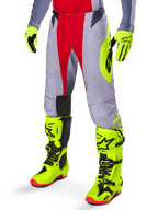 Alpinestars 2025 Techstar Melt Hose, Motocross-Hose, Hellrot und Grau, mit neongelben Seitengrafiken und schwarzen Knieeinsätzen, kombiniert mit passenden neongelben Stiefeln und Handschuhen, entwickelt für wettbewerbsorientierte Offroad-Performance