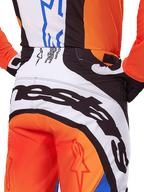 Alpinestars 2025 Techstar Melt Hose, Motocross-Hose, Orange und Blau, Nahaufnahme der Rückansicht von Gesäß und Bund, markantes schwarzes Branding auf weißem Hintergrund, orangefarbene Panels mit roten Stern-Logos, sportliche Performance-Ausrüstung für den Offroad-Rennsport