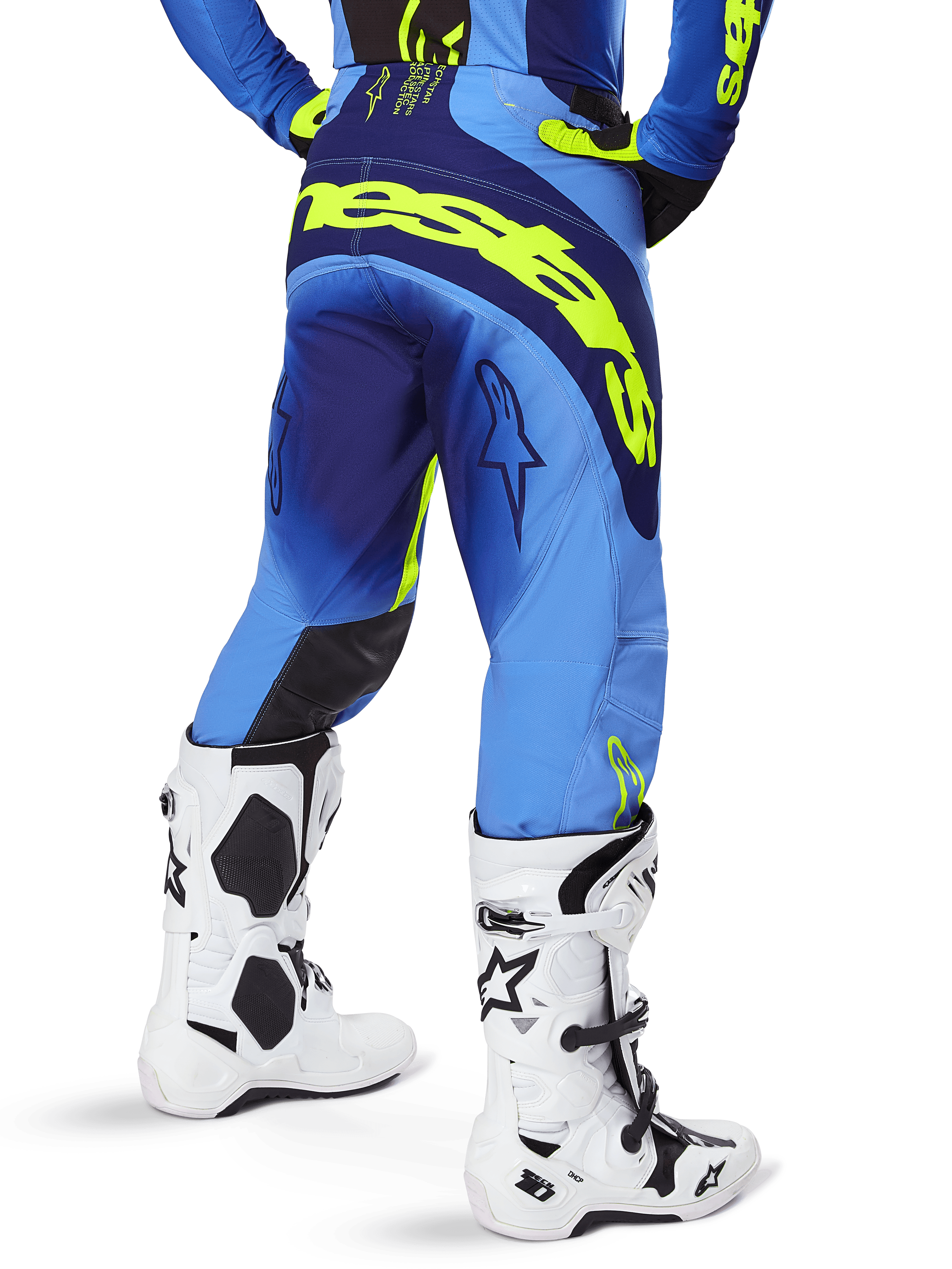 Alpinestars 2025 Techstar Melt Hose, Motocross-Hose, Blau und Gelb Fluo, Rückansicht mit großem gelbem Branding auf dem Gesäß und den Oberschenkeln, getragen mit weißen Motocross-Stiefeln und passendem blauem Trikot, athletische Rennpassform für Offroad-Fahrten