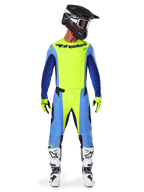 Alpinestars 2025 Techstar Melt Hose, Motocross-Hose, Gelb Fluo Blau, getragen mit passendem Trikot, gelben Handschuhen und weiß-schwarzen Stiefeln, schwarzer Helm mit roter Brille, komplette Rennausrüstung für Offroad-Performance