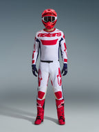 Motocross-Fahrer im Alpinestars 2026 Racer Riway Gear Set, weißes Trikot mit rotem „astars“-Branding und blauen Seiteneinsätzen, weiße Hose mit roten Grafiken, roter Helm und rote Stiefel, dunkelblaue Handschuhe, komplettes abgestimmtes Motocross-Outfit