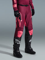 Alpinestars 2026 Racer Riway Hose, Motocross-Hose, Dark Red Coral, mit großen pinken Stern-Logos und schwarzen Knie-Innenpanelen, getragen mit schwarzen Motocross-Stiefeln und schwarzen Handschuhen, sportliche Rennpassform für den Offroad-Einsatz