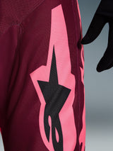 Alpinestars 2026 Racer Riway Hose, Motocross-Hose, Dark Red Coral, Nahaufnahme mit einer großen korallenrosa kantigen Grafik und schwarzem Stern-Logo, hebt die strapazierfähige Poly-Gewebe-Textur und die Performance-Nähte hervor