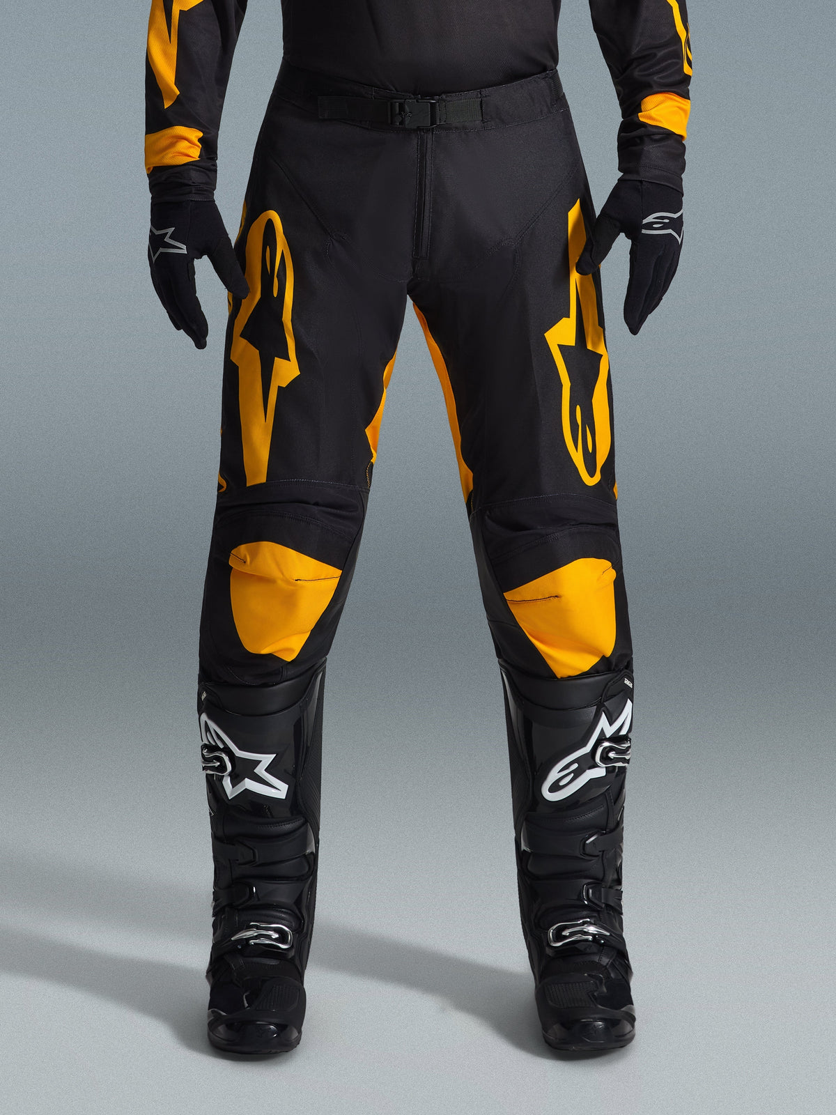 Alpinestars 2026 Racer Riway Hose, Motocross-Hose, Gelb und Schwarz, getragen mit schwarzen Motocross-Handschuhen und schwarzen Stiefeln mit weißen Logos, mit großen gelben Alpinestars-Logos auf den Oberschenkeln und gelben Knieeinsätzen, strapazierfähiges Design für Offroad-Rennleistung