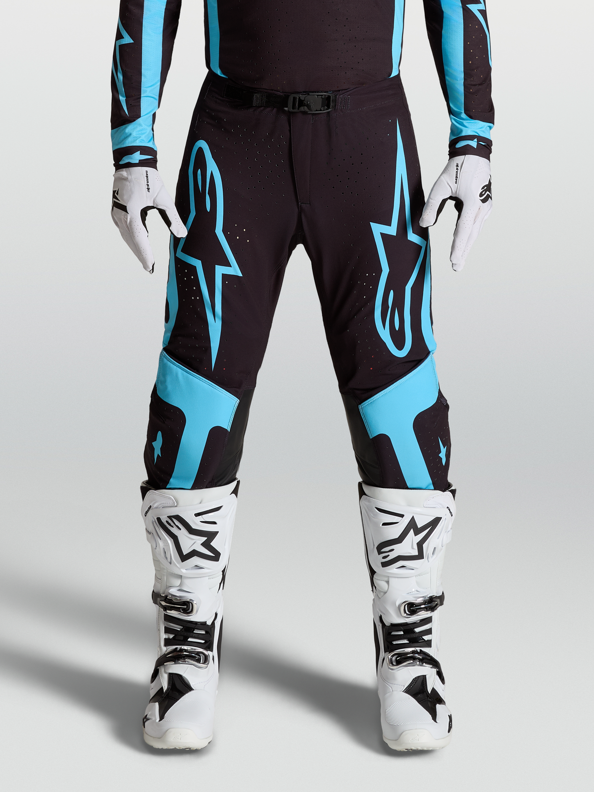Alpinestars Supertech Vesta Pants, pro motocross racing gear, Black and Turquoise with large star graphics and leather knee panels.
