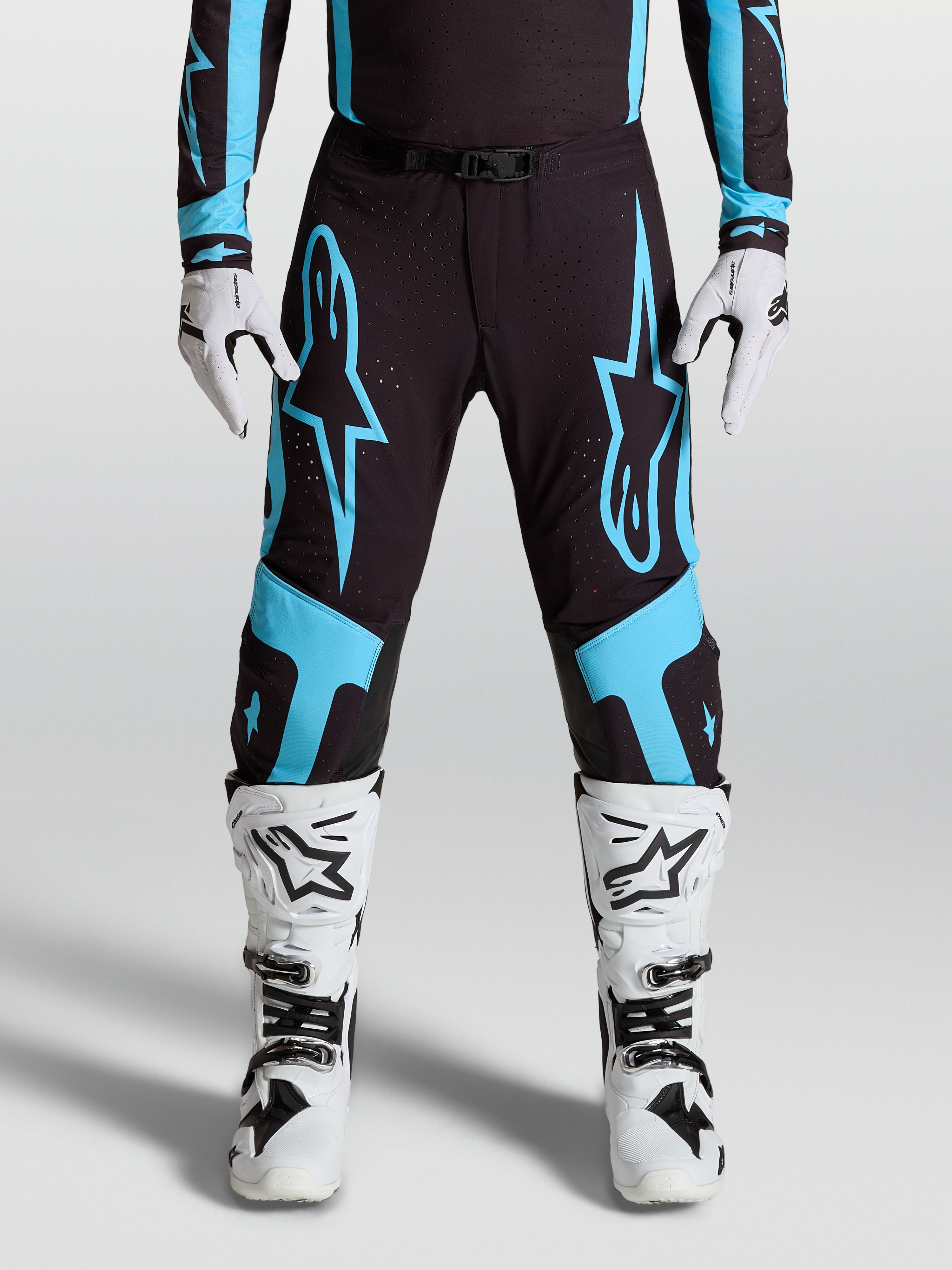 Alpinestars Supertech Vesta Hose, Motocross-Rennhose für Herren, Schwarz und Türkis mit großen Stern-Grafiken und Leder-Knie-Panels.