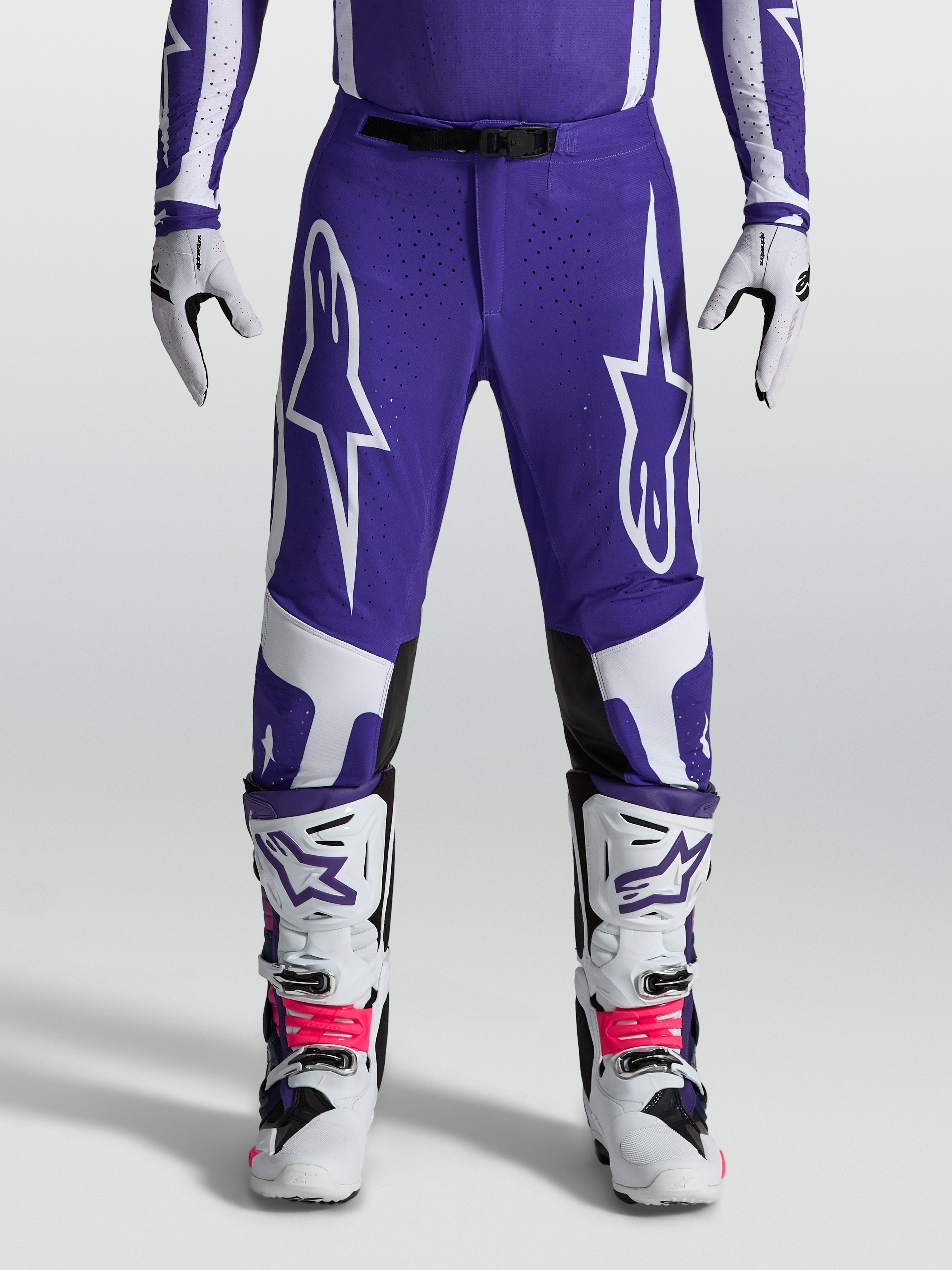 Alpinestars Supertech Vesta Hose, Motocross-Hose in Blau und Weiß, athletische Passform mit robuster Ripstop-Konstruktion, getragen mit Offroad-Stiefeln.