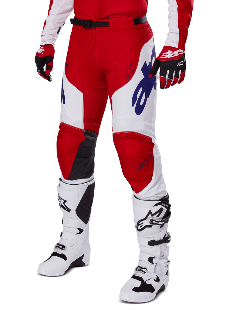 Alpinestars 2025 Racer Veil Hose, Motocross-Hose, Leuchtendes Rot und Weiß, mit blauen Alpinestars-Logos und schwarzen Leder-Innenknie-Einsätzen, getragen mit passenden roten Handschuhen und weißen Motocross-Stiefeln, abgestimmtes Ausrüstungsset für Offroad-Rennen