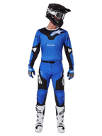 Alpinestars 2025 Racer Veil Hose, Motocross-Hose, Blau und Schwarz, getragen als komplettes Rennoutfit mit passendem blau-schwarzem Trikot, schwarz-weißem Helm, blauen Handschuhen und weißen Stiefeln, mit markanten Logos und ergonomischem Design für Offroad-Fahrten.