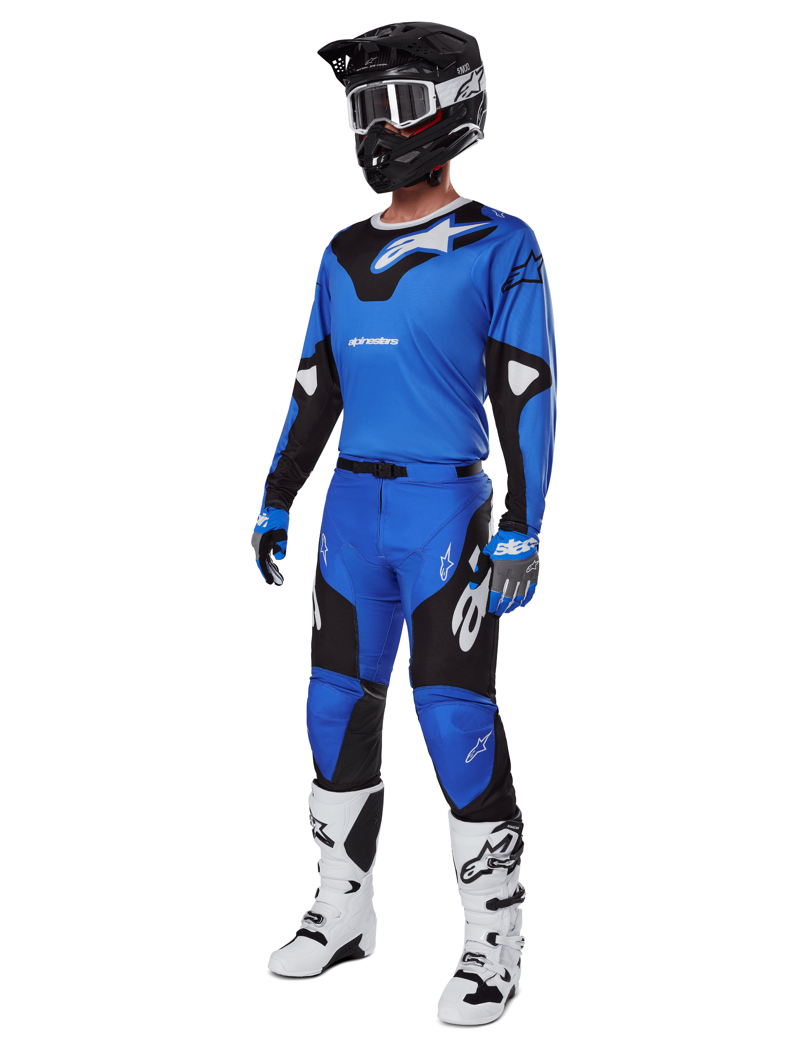 Motocross-Fahrer in kompletter Rennausrüstung, mit Alpinestars Racer Veil Hose 2025 in Blau und Schwarz, passendem blauen Trikot mit weißen Akzenten, schwarzem Helm mit weißer Schutzbrille, weiß-schwarzen Stiefeln und blauen Handschuhen, abgestimmtes Outfit für Offroad-Rennen