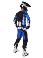 Motocross-Fahrer in der Rückansicht, trägt Alpinestars 2025 Racer Veil Hose in Blau und Schwarz, passendes Langarm-Trikot mit weißem Branding, weiß-schwarze Tech 7 Stiefel und einen schwarzen SM10 Helm, komplettes Offroad-Racing-Gear-Set
