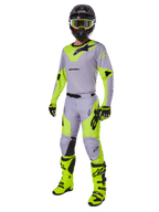 Alpinestars 2025 Racer Veil Hose, Motocross-Hose, Grau und Gelb Fluo, getragen mit passendem Trikot, schwarzem Helm, fluogelber Brille, Stiefeln und Handschuhen, koordiniertes Offroad-Rennoutfit mit markantem Branding und ergonomischem Design.