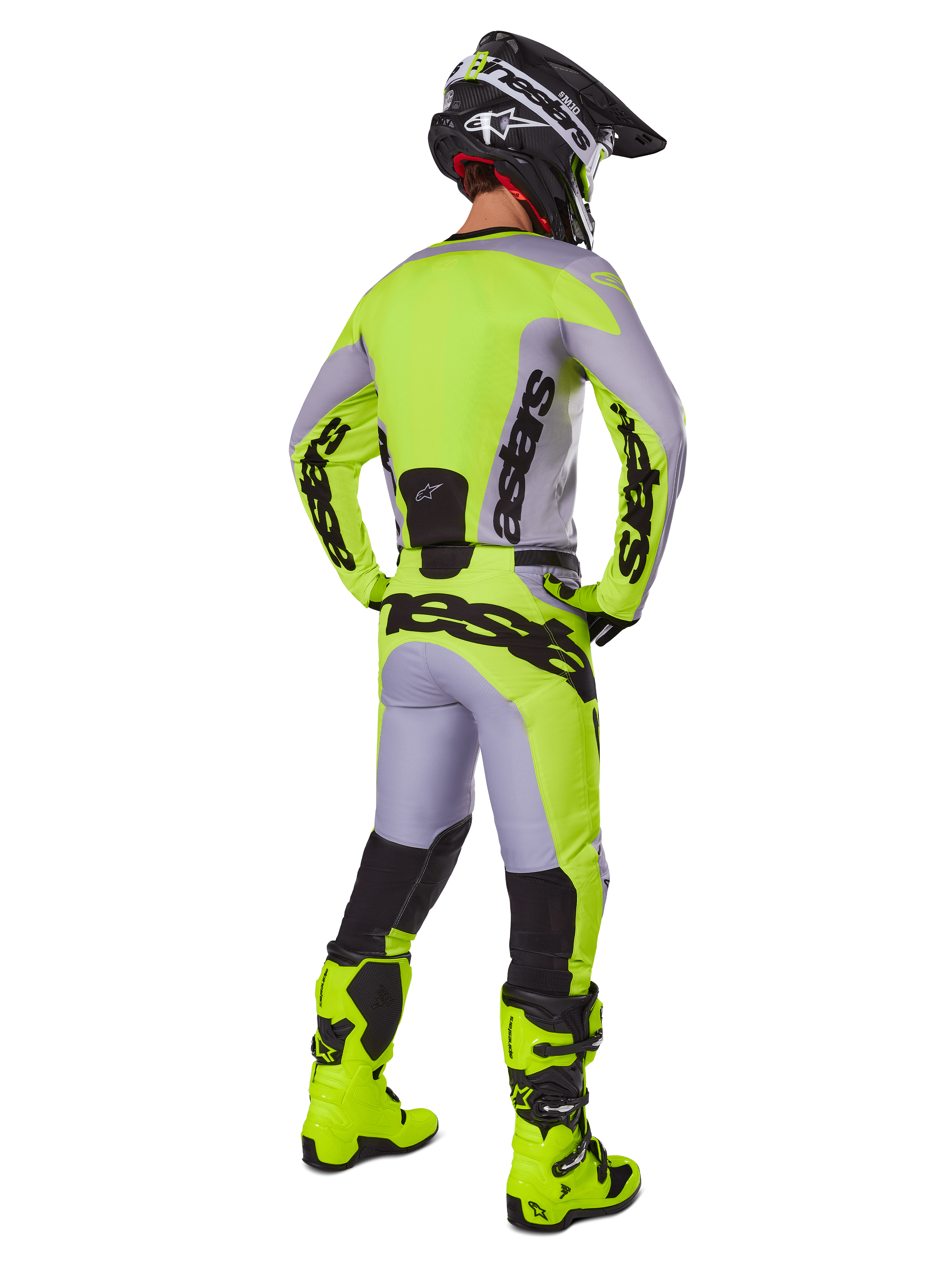 Alpinestars 2025 Racer Veil Hose, Motocross-Hose, Grau und Neongelb, Rückansicht eines Fahrers in kompletter Ausrüstung, passendes Trikot und neongelbe Stiefel, mit auffälligen schwarzen Logos, technische Offroad-Rennausrüstung