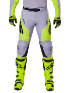 Alpinestars 2025 Racer Veil Hose, Motocross-Hose, Grau und Gelb Fluo, getragen mit passenden neongelben Stiefeln und Handschuhen, mit schwarzen Alpinestars-Logos, ergonomisches Design für Offroad-Rennsport.