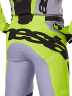 Alpinestars 2025 Racer Veil Hose, Motocross-Hose, Grau und Gelb Fluo, Rückansicht mit großem schwarzen Branding am Gesäß, getragen mit passendem Trikot und Handschuhen, technisches Offroad-Design