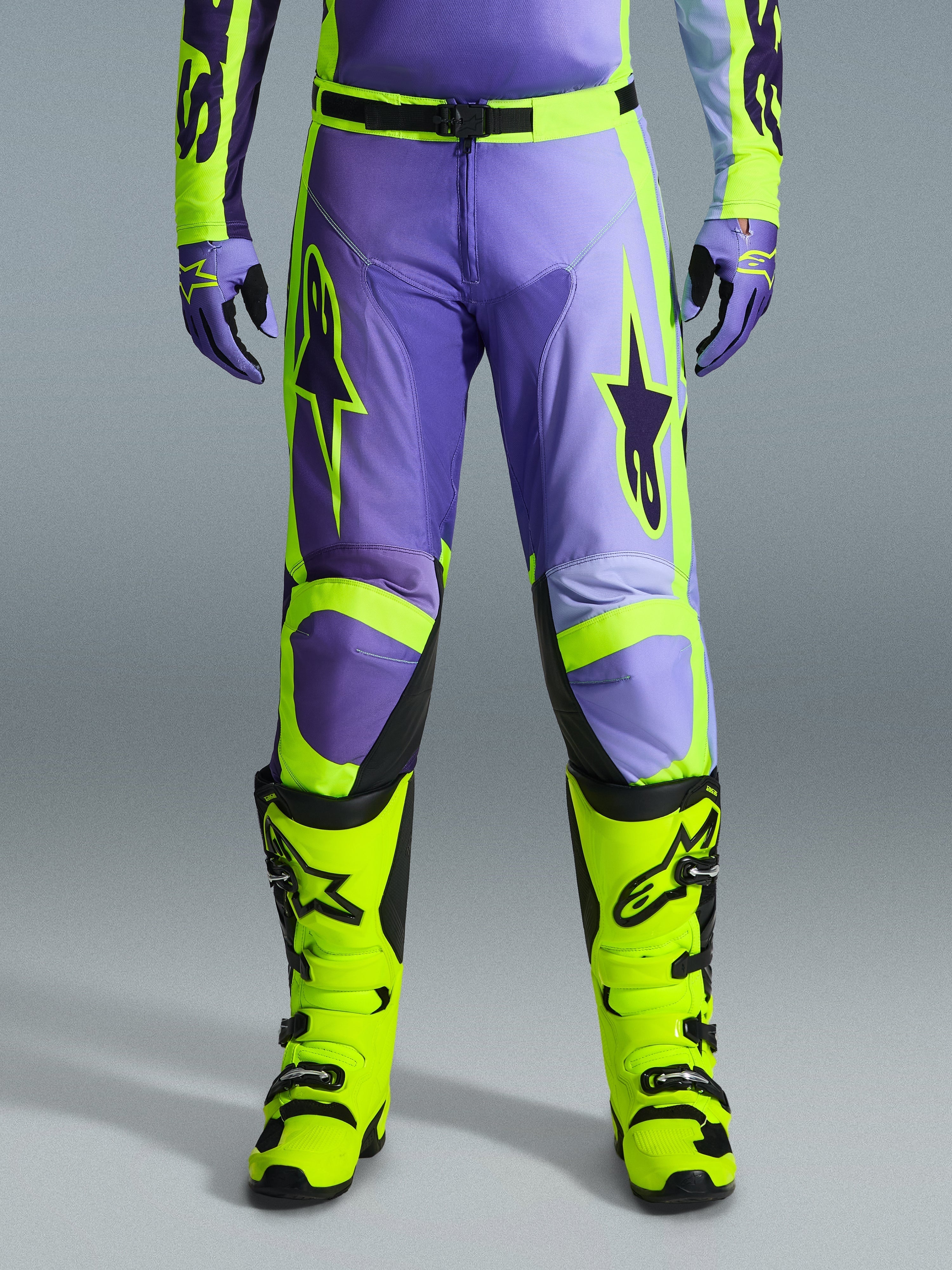 Alpinestars 2026 Racer Portl Hose, Motocross-Hose, Lila und Neongelb, getragen mit passenden neongelben Stiefeln und lila Handschuhen, mit großen Stern-Logos und strapazierfähiger Polygewebe-Konstruktion für den Offroad-Rennsport