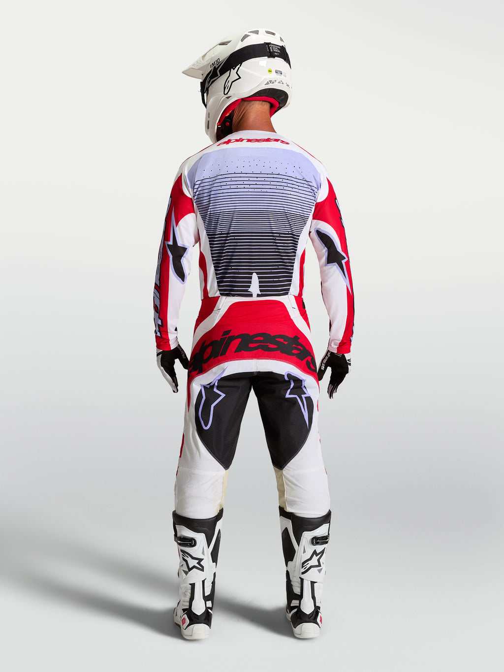 Alpinestars Techstar Maven Motocross-Hose, Rot und Weiß, athletische Rennpassform, Rückansicht am Fahrer.