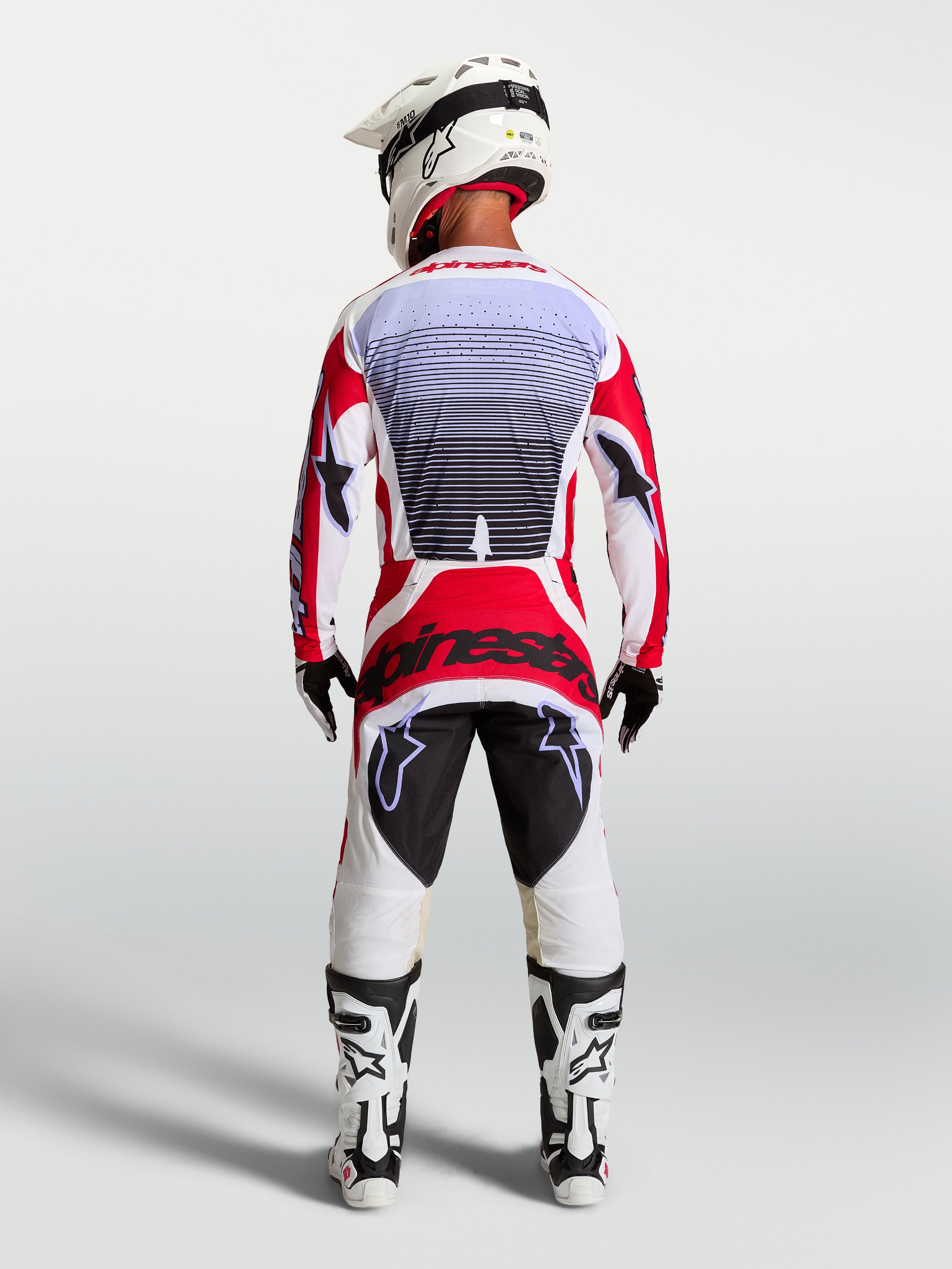 Alpinestars Techstar Maven Motocross-Hose, Rot und Weiß, athletische Rennpassform, Rückansicht am Fahrer.
