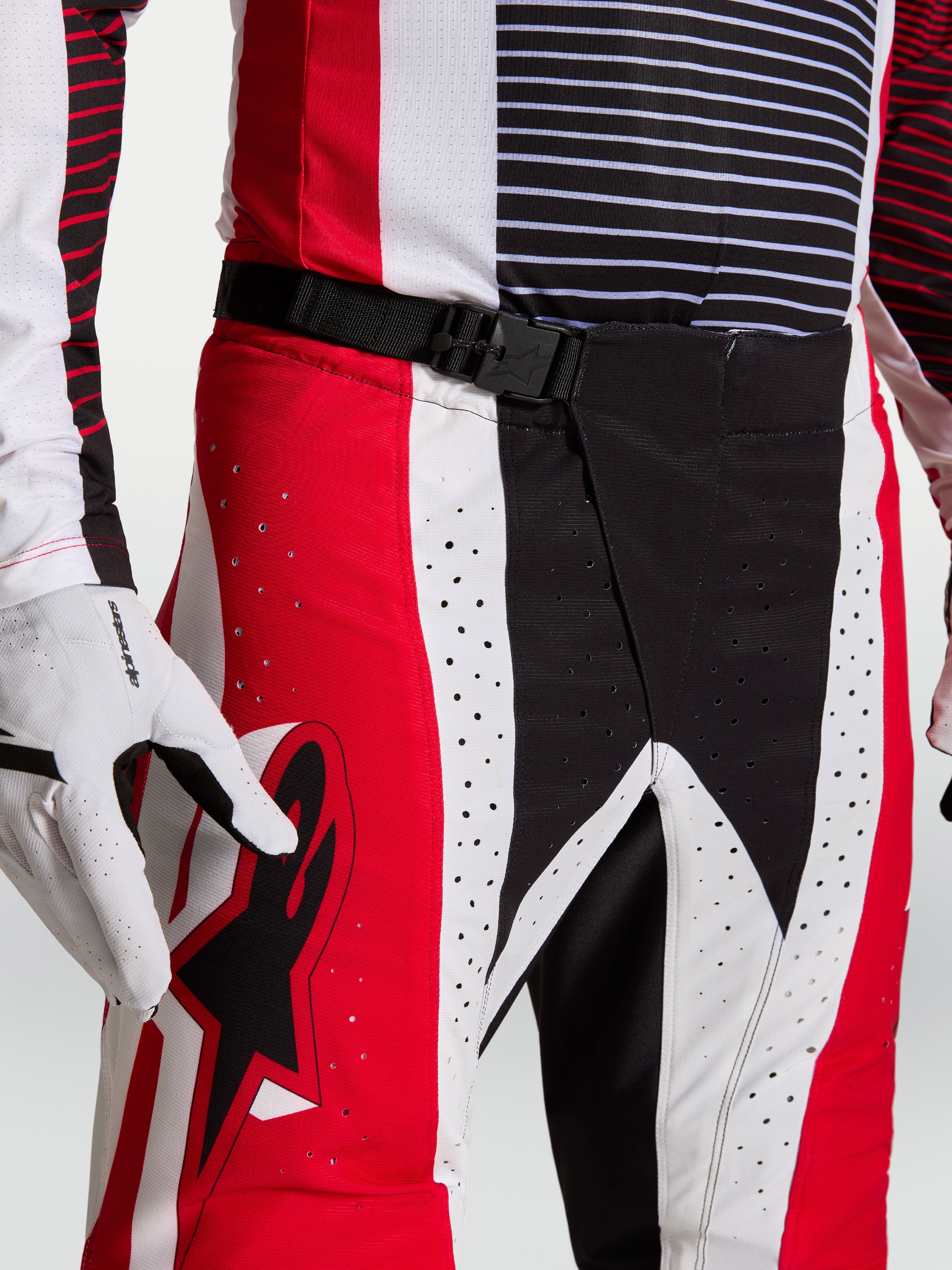 Alpinestars Techstar Maven Hose, Motocross-Hose in Rot und Schwarz mit SX2-Magnetverschluss und Laserperforationen am Taillenbund.
