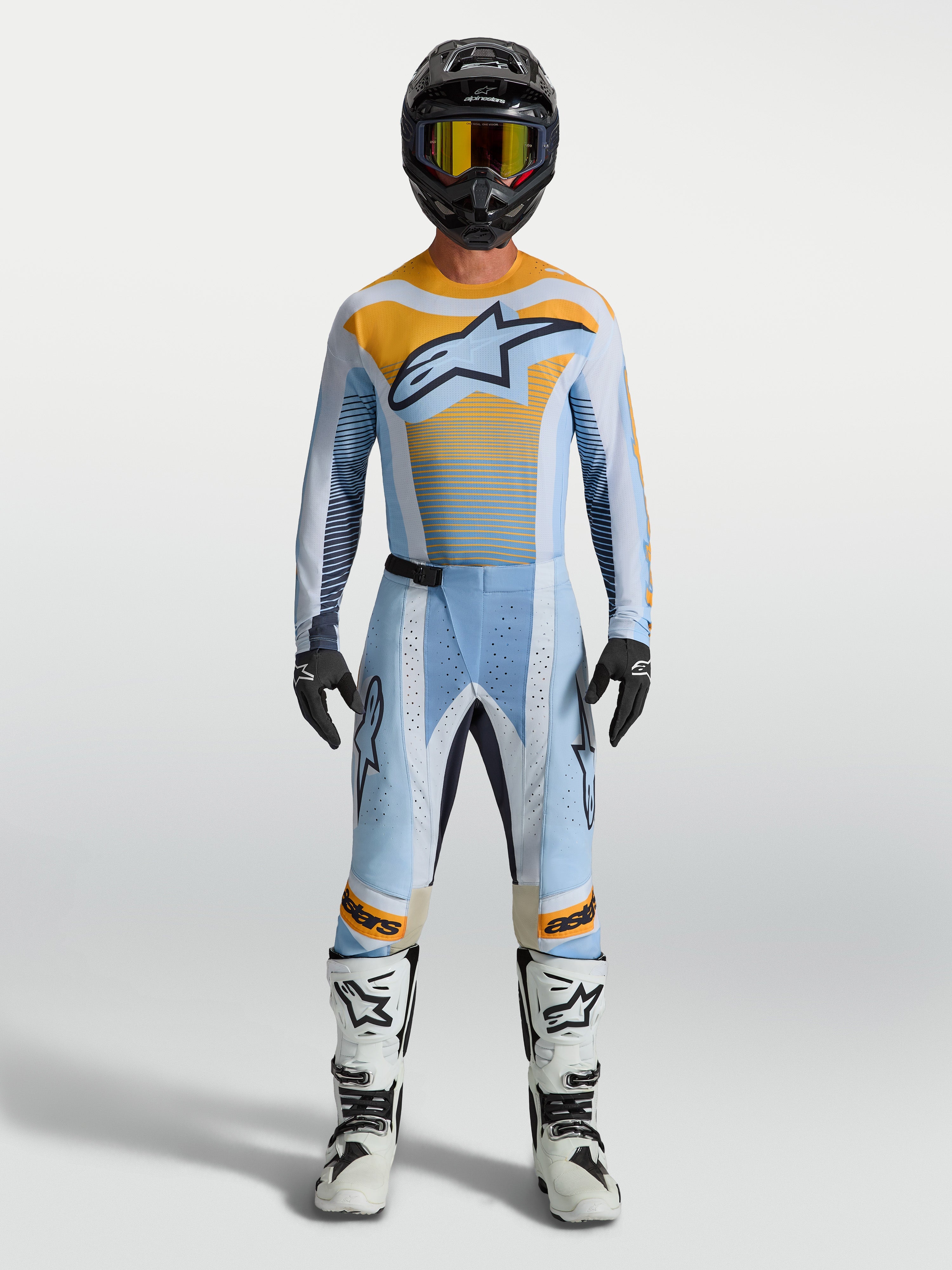 Alpinestars Techstar Maven Hose, Motocross-Hose für Herren, Hellblau und Orange, mit Rennpassform und Stretch-Zonen, getragen von einem Modell in kompletter MX-Ausrüstung.