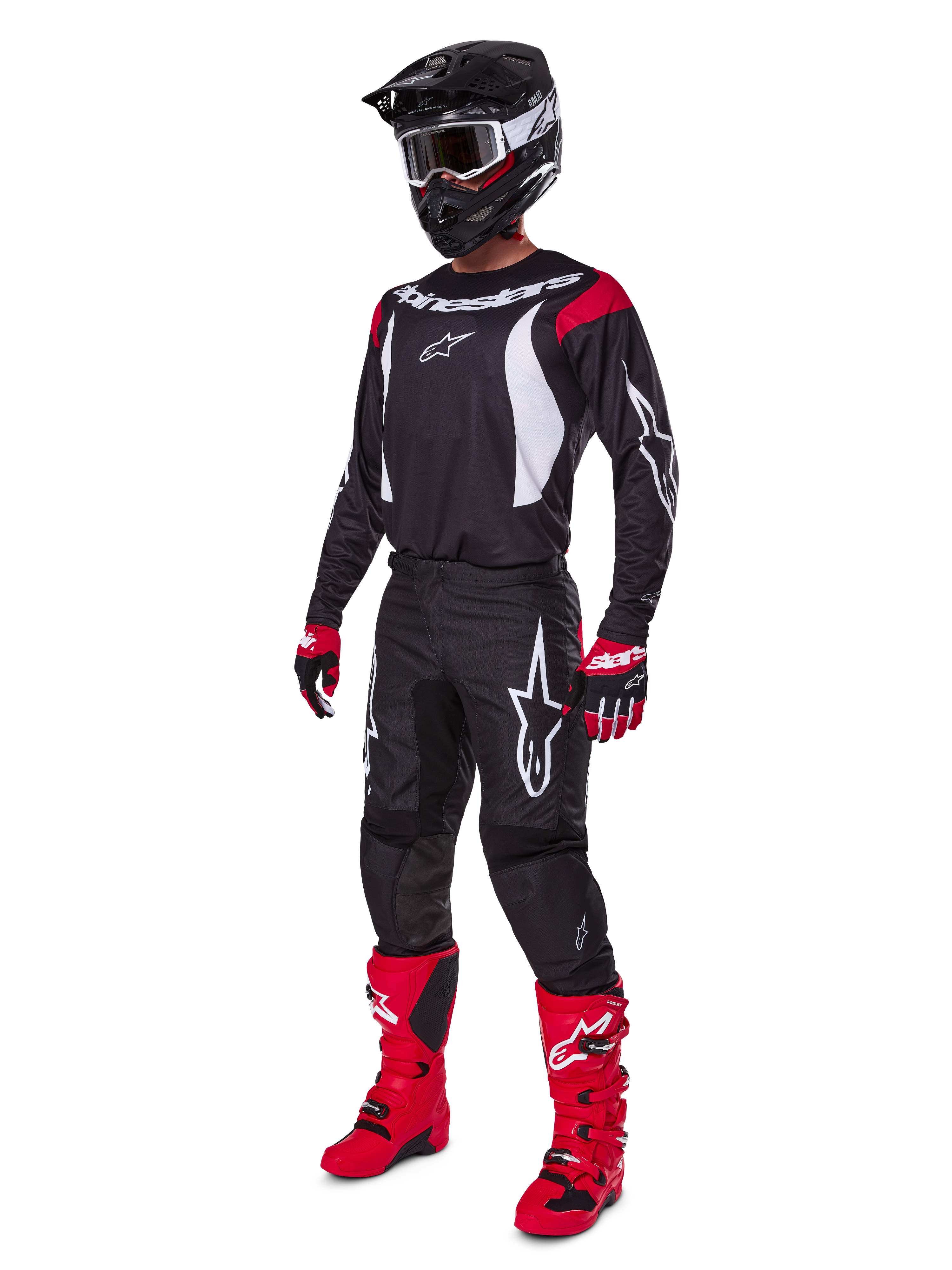 Motocross-Fahrer im kompletten Alpinestars 2025 Fluid Haul Ausrüstungsset, schwarzes Jersey mit roten und weißen Akzenten, schwarze Hose mit weißen Logos, leuchtend rote Stiefel, rote und schwarze Handschuhe, schwarzer Helm mit Brille, abgestimmte Offroad-Performance-Ausrüstung
