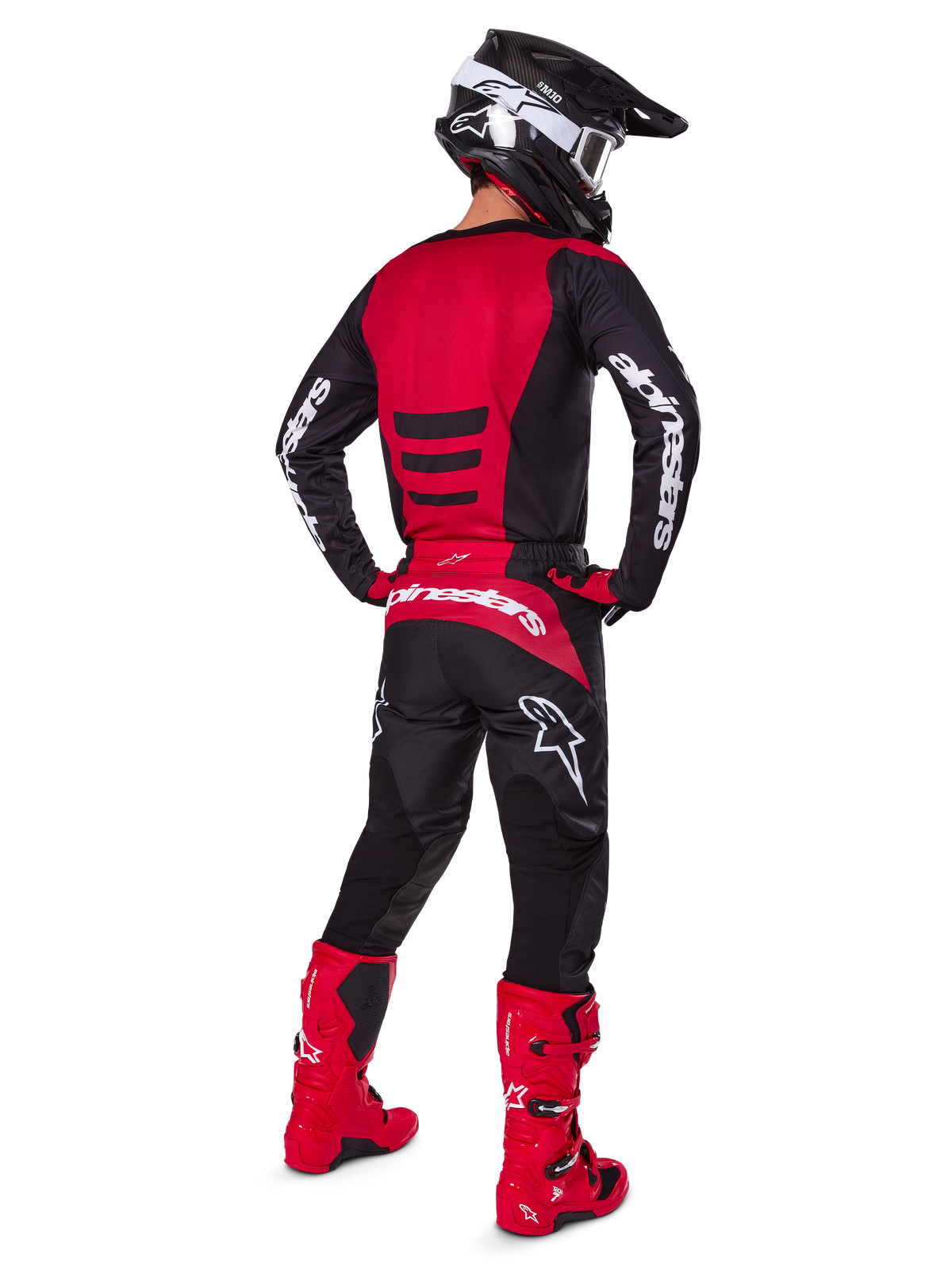 Motocross rider wearing the Alpinestars 2025 Fluid Haul Gear Set from a rear view, Red and Black jersey with white branding, matching black pants with red accents, bright red boots and black helmet with white goggles, complete coordinated outfit for off-road racing