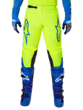 Alpinestars 2025 Fluid Haul Hose, Motocross-Hose, Leuchtendes Gelb und Blau, getragen mit passenden Handschuhen und Stiefeln, schwarze Knieinnenseiten, markantes blaues Branding auf den Oberschenkeln, sportliches ergonomisches Design