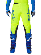 Alpinestars 2025 Fluid Haul Hose, Motocross-Hose, Leuchtendes Gelb und Blau, getragen mit passenden Handschuhen und Stiefeln, schwarze Knieinnenseiten, markantes blaues Branding auf den Oberschenkeln, sportliches ergonomisches Design