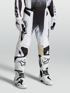 Alpinestars Techstar Swan Hose, Motocross-Rennausrüstung am Model, Weiß und Schwarz, aus strapazierfähigem Stretch-Ripstop mit passenden Stiefeln.