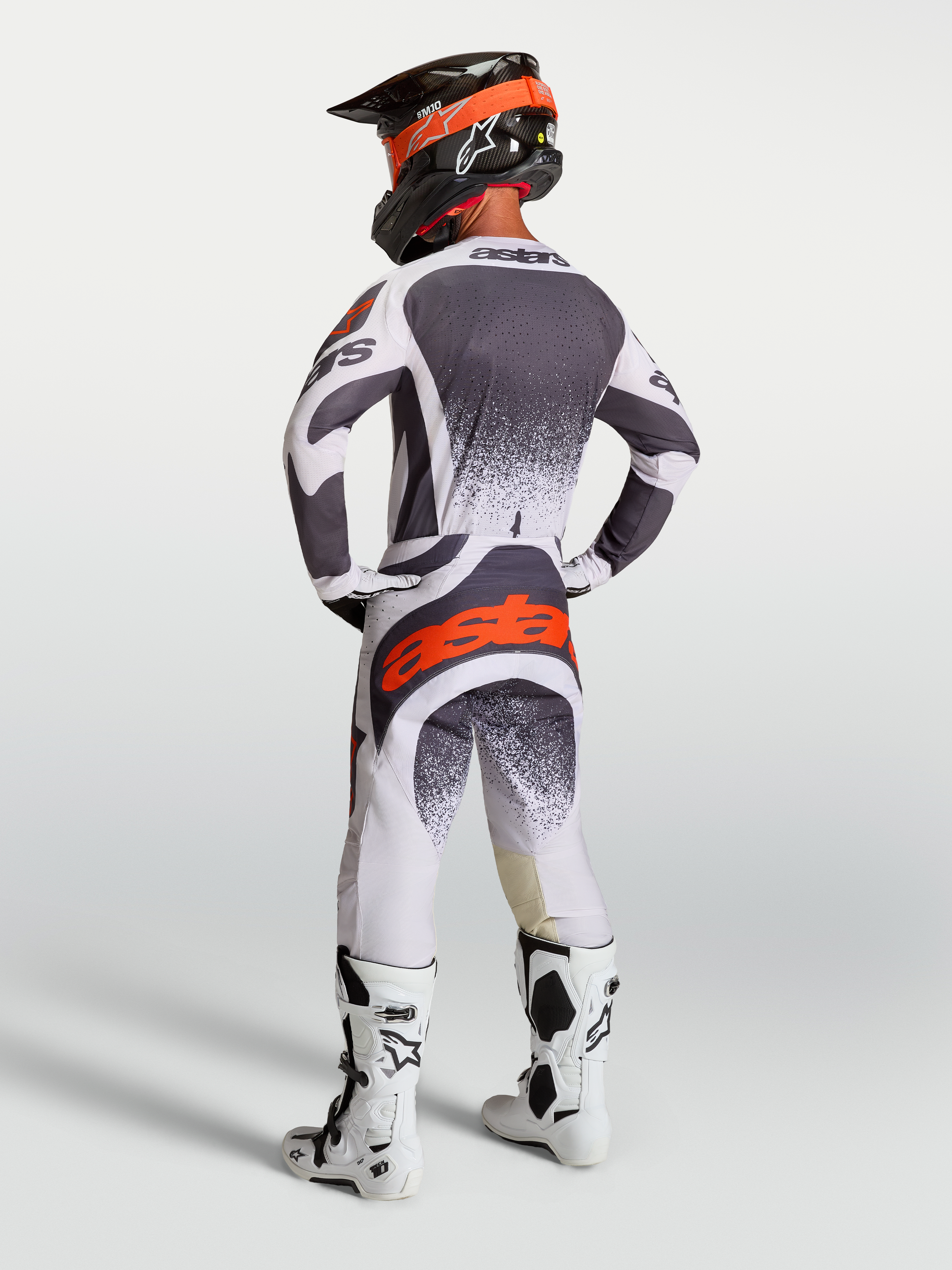 Alpinestars Techstar Swan Hose und Trikot, Herren-Motocross-Ausrüstung, Grau und Weiß mit roten Fluo-Akzenten, Rückansicht am Modell.