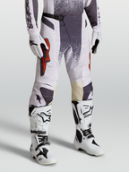 Alpinestars Techstar Swan Hose, Motocross-Hose für Herren, Hellviolett und Dunkelgrau mit roten Akzenten, On-Model-Foto mit Handschuhen und Stiefeln