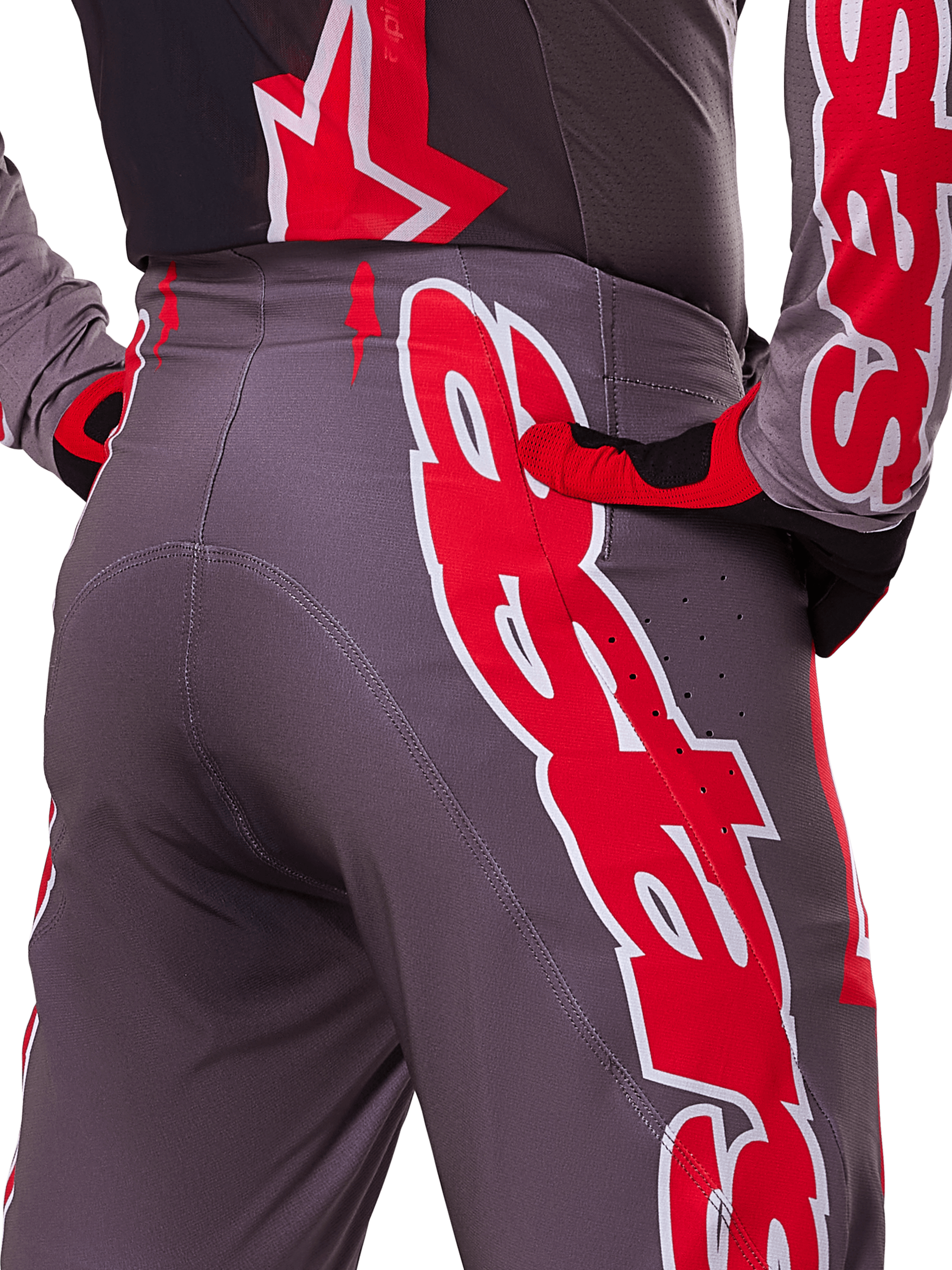 Alpinestars 2025 Supertech Lipan Pants, Motocross Pants, Smoke Bright Red and Gray, close-up of hip and rear showing bold red and white logo graphics, ventilation perforations, and athletic race fit worn with matching gear.